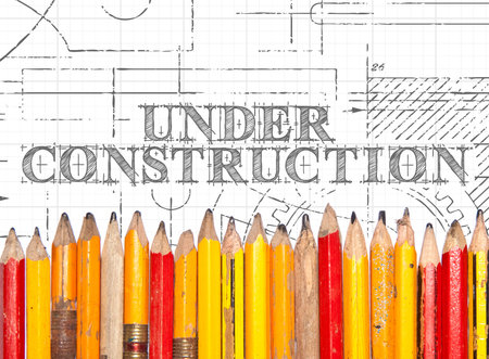 Under construction hand drawn sign and line of old pencilsの写真素材
