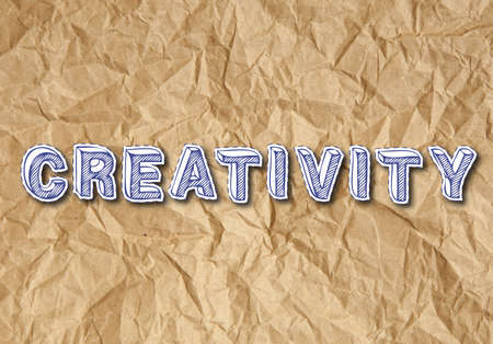 Creativity paper letters text on crumpled brown paper backgroundの写真素材