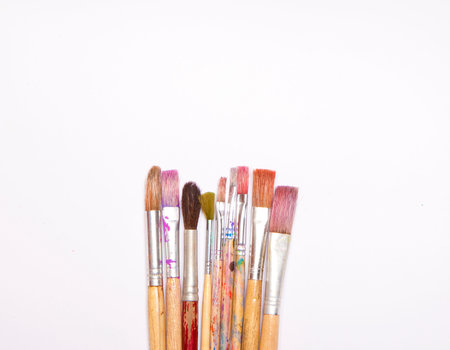 Used artists paint brushes different colors on white backgroundの写真素材