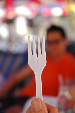 White plastic fork holding by a hand