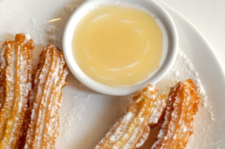 Authentic sugar icy Spanish churros with white chocolate dipping sauce