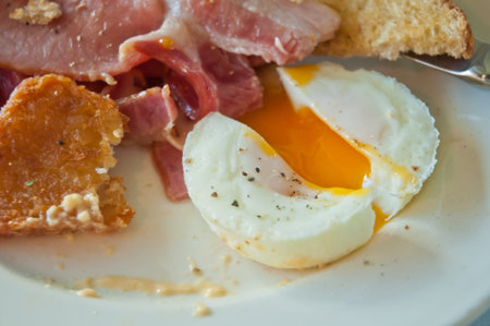 English breakfast - poached yummy half-cooked eggs and baconの写真素材