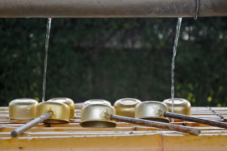 Japanese sacred ladles and holy water in local shrine in Kyotoの写真素材