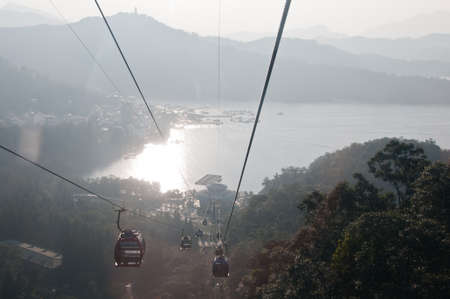 Nantou Taiwan  January 31 2015: Tourist cable cars are going up to the mountain in Sun Moon Lake area in Nantou province in Taiwan. This photo is taken in the late afternoon. There are tourists in many cable cars. The cable cars are going up to Taiwanese のeditorial素材