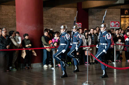 Taipei Taiwan  February 3 2015: Guards are changing at Sun Yat Sen Memorial hall in Taipei Taiwan. This photo is taken in the morning shift inside the central section of the hall. The soldier are carrying traditional rifles with blue flag and marching pasのeditorial素材