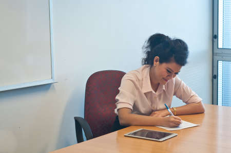 Business woman writing on a paper noteの写真素材