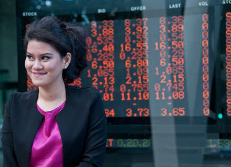Business woman stand near stock market exchange boardの写真素材