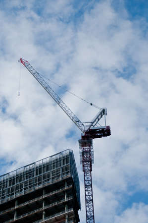 Construction crane and unfinished building look upの写真素材