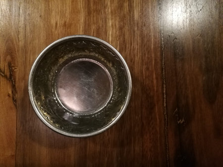 Silver traditional water bowl cup Thailand style on wood tableの写真素材