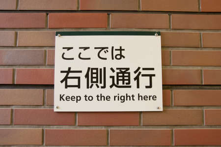 Japanese text banner to keep to the right here sign on brick wallの写真素材