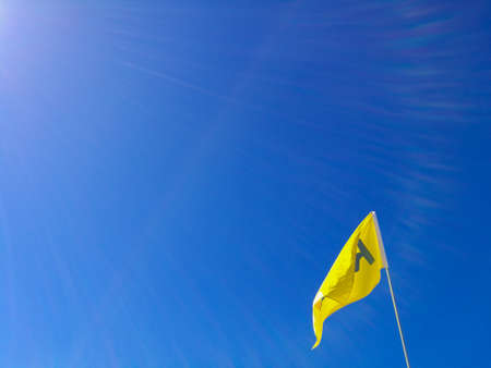 Flying flag of letter A with blue bright skyの写真素材