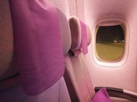Pink economy seats of airplane at nightの写真素材