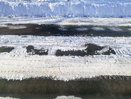 Winter road track snowy path on asphalt streetの写真素材