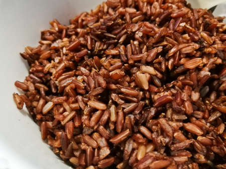 Dark red brown organic Thai rice in a bowlの写真素材