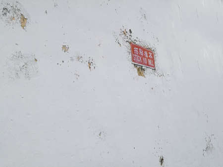 White concrete wall with red stick no bill post signの写真素材