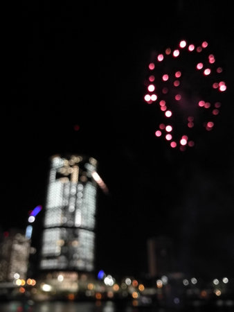 Defocused abstract scene of riverside firework in city center at night to celebrate festive eventの写真素材