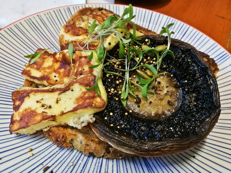 Greek halloumi with grilled portobello mushroom on crispy toast bread in a cafeの写真素材