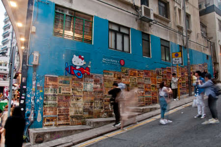 HONG KONG, HONG KONG SAR - NOVEMBER 17, 2018: Scene of blurred motion of moving people with Hong Kong famous street graffiti painting. The painting is Tong Laus on Graham Street in Soho area. Tong Laus is a building type in Hong Kong. There are many peoplのeditorial素材