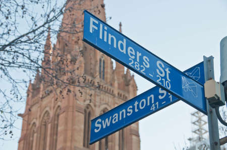 MELBOURNE, AUSTRALIA - JULY 29, 2018: Street signs of Flinders St and Swanston St in front of St Paul's Cathedral in Melbourne central business district near Federation square. The photo is taken in the afternoon.のeditorial素材