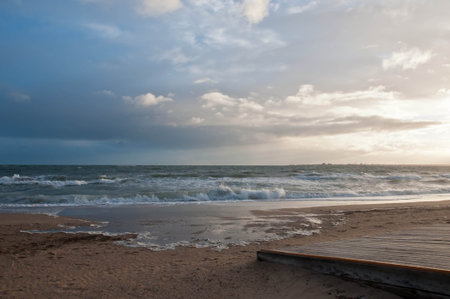 Beautiful blue cloudy sky with strong high tide wave of sea ocean creep to golden beach and wooden...