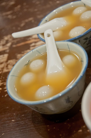 Many bowls of famous hot and cold sweet dessert soup in a round table with her friend in Hong Kong...