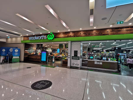 BRISBANE, AUSTRALIA - MAY 24, 2020: Front of Woolworths groceries shopping department supermarket. There is a warning sign to stay social distancing during Covid19 time.のeditorial素材