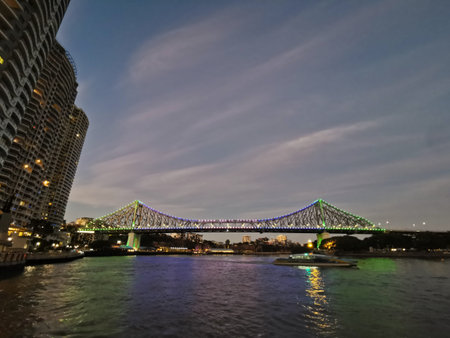 BRISBANE, AUSTRALIA - JULY 10, 2020: Twilight scene of famous Story Bridge and City Cat ferry in...