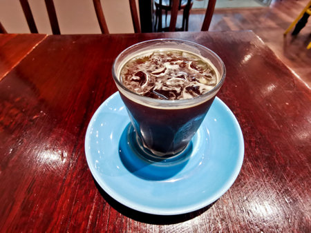 Cold brew iced fresh Americano coffee served in a glass on wooden tableの写真素材