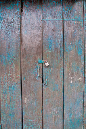 Old dark cyan wooden closed door of a traditional house in Asia with golden lockの写真素材