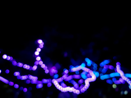 Defocused abtract blurred artistic blue purplr light dots in dark backgroundの写真素材
