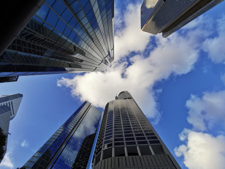 Lookup view of variety of coporate business high-rise skyscrapers buildings with blue bright sky in central business distric downtownの写真素材
