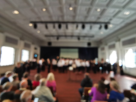 Defocused abtract blurred scene of chorus performance in the music hall with many audienceの写真素材