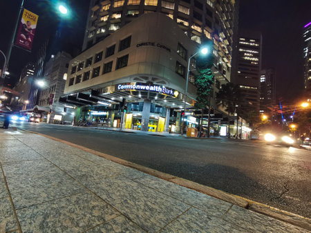 BRISBANE, AUSTRALIA - MAY 29, 2020: Commonwealth Bank of Australia (CBA) flagship headquarters office high-rise building in Brisbane Central Business District on Queen Street at night. There is car traffic movement.のeditorial素材