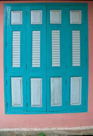 Cyan blue dark closed traditional old window panes on pink wallの写真素材