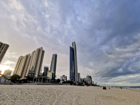 GOLD COAST, AUSTRALIA - AUGUST 15, 2020: Gold Coast Surfer Paradise open beach with blue sky and high-rise skyscrapers hotels. There are many people relax and sit on the beach.のeditorial素材