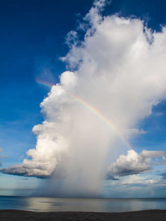 Rainbow with fluffy clouds at the sea, Andaman, Thailandの写真素材