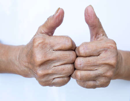 Senior woman's hands shaping mean " Good "symbol isolated on white backgroundの写真素材