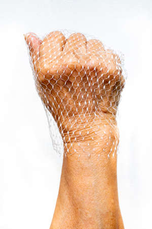 Senior woman's hands wear plastic net bag on white backgroundの写真素材