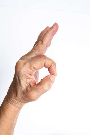 Senior woman's left hand symbol mean " OK "の写真素材