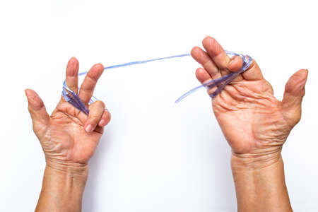 Senior woman's hands pulling blue plastic rope on white backgroundの写真素材