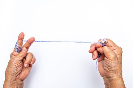 Senior woman's hands pulling blue plastic rope on white background