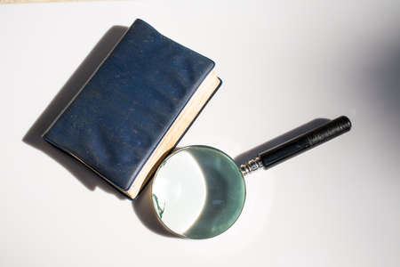 Old magnifying glass with old notebook isolated on white background, Light and Shadowの写真素材