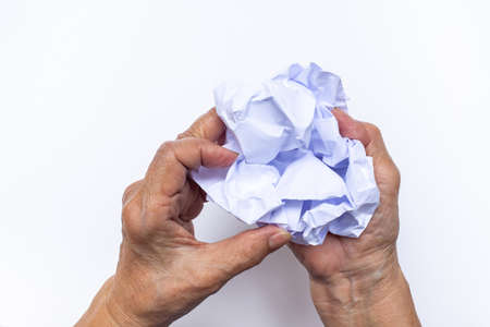 Senior woman's hand crumpling white paper isolated on white background, Angry moodの写真素材