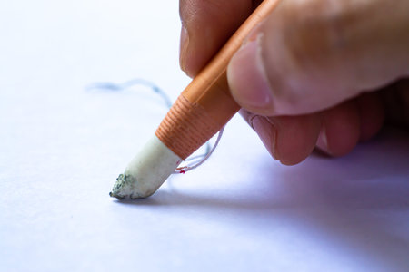Woman's right Hand holding dermatograph pencil writing letter on white paper texture background,...