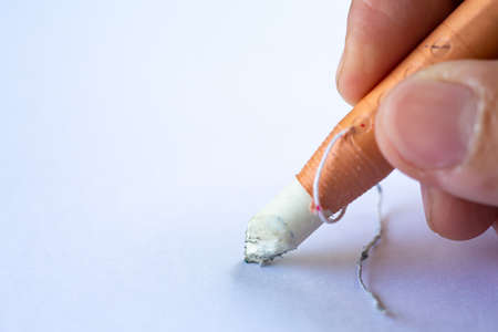 Woman's right Hand holding dermatograph pencil writing letter on white paper texture background, Notebook, Close up & Macro shot, Selective focus, Communication, Stationery conceptの写真素材