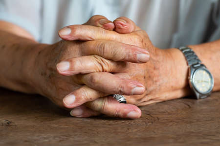 Senior man's holding his hands and praying, Close up & Macro shot, Selective focus, Asian Body skin part, Body language feeling, Religious conceptの写真素材