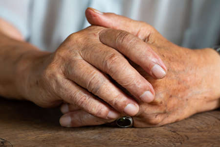 Senior man's holding his hands and praying, Close up & Macro shot, Selective focus, Asian Body skin part, Body language feeling, Religious conceptの写真素材