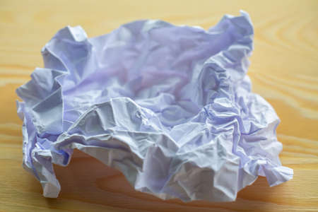 Crumpled white paper on wood table, Close up & Macro shot, Selective focus, Brainstorming, Creative idea, Business conceptの写真素材