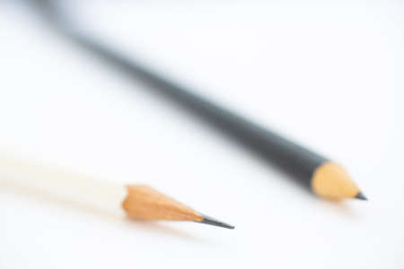 A white pencil with a black pencil on white background, Close up & Macro shot, Selective focus, Stationery conceptの写真素材