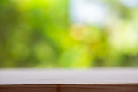 Empty wooden table texture, Green garden blurred bokeh background, Selective focusの写真素材